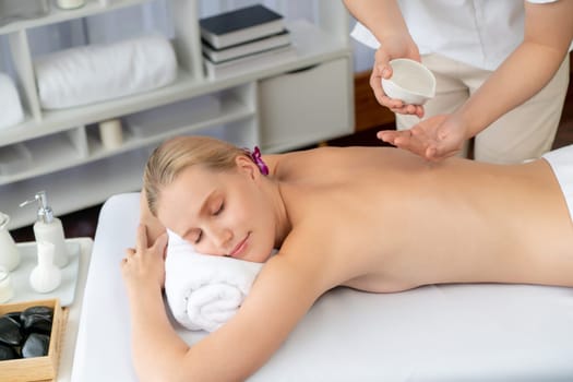 Masseur hands pouring aroma oil on woman back. Masseuse prepare oil massage procedure for customer at spa salon in luxury resort. Aroma oil body massage therapy concept. Quiescent