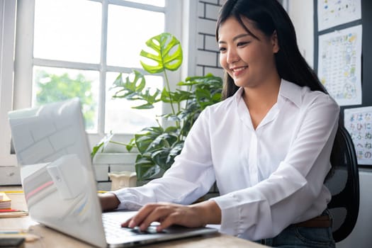 Back to school. Portrait of young woman teacher with laptop at desk in classroom, Smiling female using computer sitting at school table, Online education and learning concept