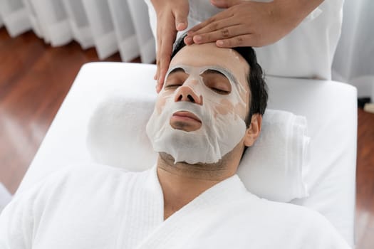 Serene modern daylight ambiance of spa salon, woman customer indulges in rejuvenating with facial skincare mask. Facial skin treatment and beauty cosmetology procedure for face. Quiescent