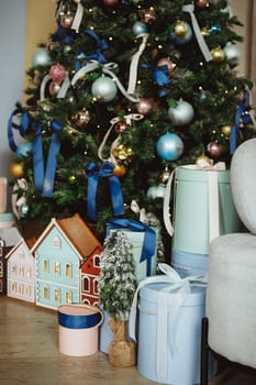 Gift boxes under the Christmas tree close-up. Gifts near the Christmas tree in blue and white paper.