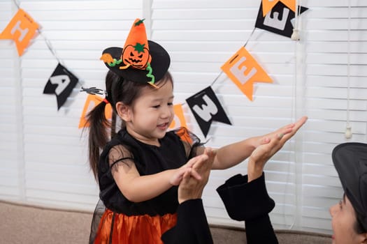 A mother and daughter celebrate Halloween, dressed in festive costumes, enjoying the joy and spirit of the holiday together.