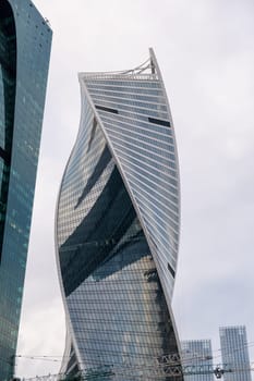 Modern Moscow City towers against a blue sky. Tall glass skyscrapers with reflective facades create a dynamic urban landscape. Perfect for business and architecture themes.