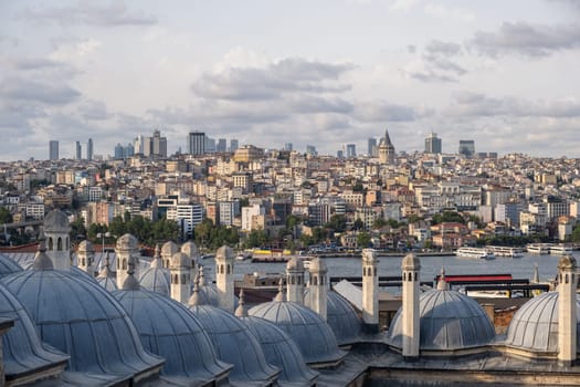 The skyline of Istanbul showcases a blend of modern skyscrapers and historic buildings near the Bosphorus, framed by beautiful clouds.