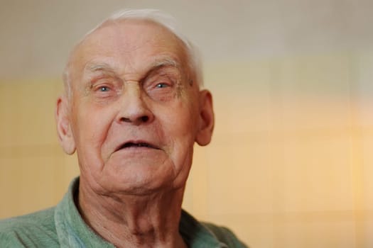 Elderly man with profound expression captured indoors, showcasing wisdom and life experience in soft lighting