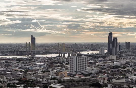 Bangkok, Thailand - 04 Sep, 2024 - Amazing Clouds and Sky over Metropolitan City alongside the iconic landmark of Bhumibol Bridge with Chao phraya river before sunset. Bangkok city skyscrapers with Dramatic sky background. use it as your wallpaper, poster and banner design, Space for text, Selective focus.