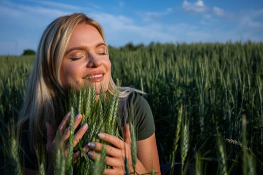 In the heart of the field, a smiling female farmer affectionately embraces towering ears of grain. Her radiant smile reveals her teeth as she lovingly cradles the lush wheat with both hands. With closed eyes, she immerses herself in the moment, savoring the connection to her harvest. The wheat stalks, reaching impressive heights, surround her in a sea of green and gold. Each ear of grain represents the culmination of her hard work and dedication to farming. Against the backdrop of the sunlit landscape, her joyful expression adds a touch of warmth to the scene. This captivating image captures the essence of agricultural bliss, where the beauty of nature intertwines with the satisfaction of a successful harvest. It celebrates the bond between farmer and field, where each ear of grain tells a story of growth, abundance, and the promise of a bountiful yield. The sun illuminates her face.