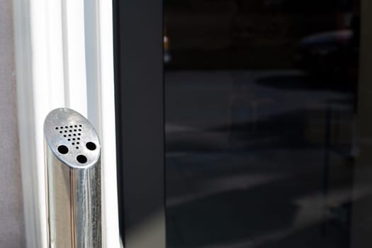 Outdoor ashtray for cigarettes, pole with hole for throwing away cigarette butts in smoking area, modern problem of people smoking and unhealthy lifestyle