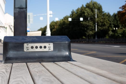 Bench with built in USB connectors for charging mobile devices and accurate Wi-Fi access. Modern public transport stop in metropolis street with bench for waiting bus and charging phone
