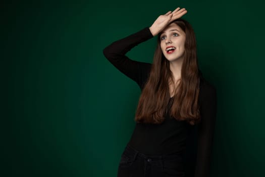 A woman, dressed in a black shirt, is striking a pose for a photograph. She is standing confidently and looking directly at the camera, showcasing her stylish outfit.