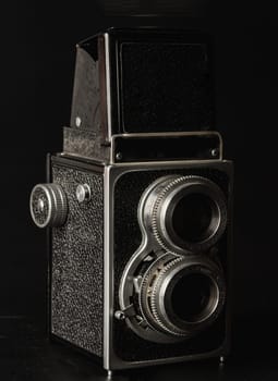 Bangkok, Thailand - 17 Sep, 2024 - Vintage twin lens reflex photo camera or Old two lens medium format film camera on black background. An idea of old camera and memory, Light and Shadow, Space for text, Selective focus.