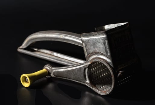 Bangkok, Thailand - 18 Sep, 2024 - Antique cheese grater on dark background. Light and Shadow, Space for text, Selective focus.