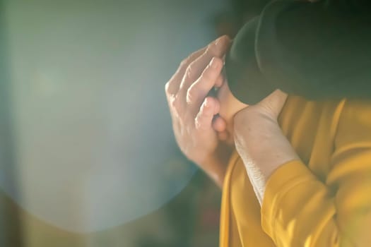 A young man, a volunteer, a son carefully hugs his beloved grandmother, supports and helps an elderly woman in retirement, his grandparent. Young male and female elderly hands with wrinkles closeup.