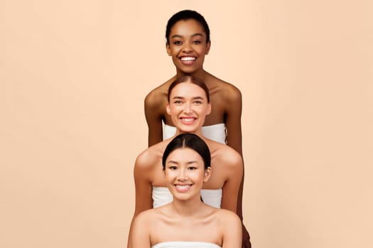 Group Of Three Diverse Women Standing And Posing Smiling At Camera Over White Studio Background. Vertical Beauty Portrait