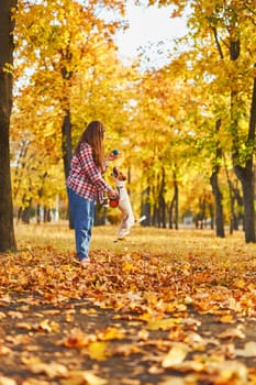 Happy joyful little girl playing with her funny Jack Russell Terrier in beautiful autumn forest, child playing and having fun with dog during walk in nature. Children and pets outdoors
