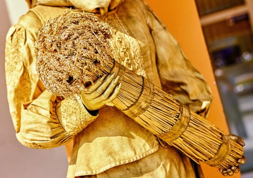 The golden figure captures attention with its exquisite craftsmanship while delicately holding a beautifully arranged bundle, blending art and creativity in the heart of the city.