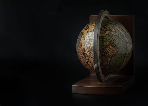 Replica Globe or World Globe Map on dark background. Unique Geography Earth Globe Home Decor, Light and Shadow, Space for text, Selective focus.