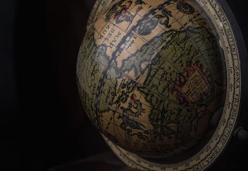 Bangkok, Thailand - 19 Sep, 2024 - Close-up of Replica Globe or World Globe Map on black background. Unique Geography Earth Globe Home Decor, Light and Shadow, Copy space, Selective focus.