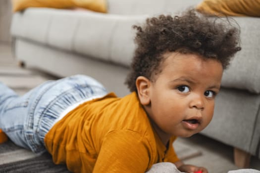 A curious toddler crawls on the rug in a warm, inviting living room.