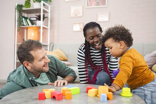 A joyful family enjoys playtime with building blocks in their cozy living space.