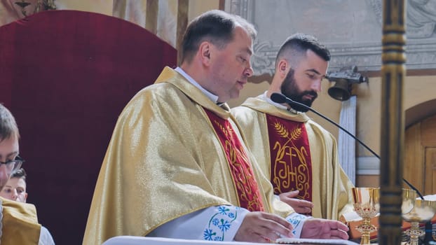 Two priests wearing traditional clothes, celebrating a mass in a church