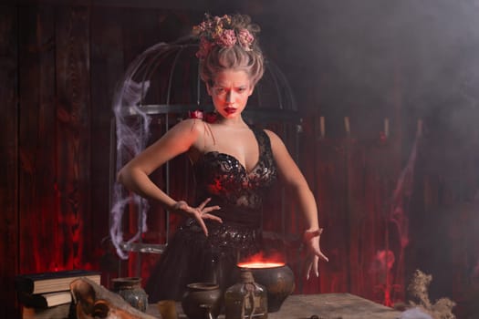Halloween witch with cauldron. Young woman conjuring, making witchcraft standing spooky dungeon dark room. Enchantress prepare love potion using magic spell.