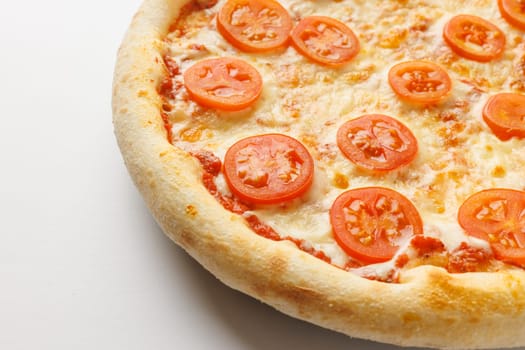 Close-up of a cheese pizza topped with tomato slices on a white background.