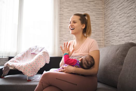 A mother happily breastfeeds her baby in a warm, inviting space.