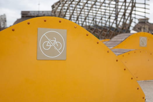Sign prohibiting the use of decorative bench for bicycle stunts, safe movement in public park, prohibition of using bicycle