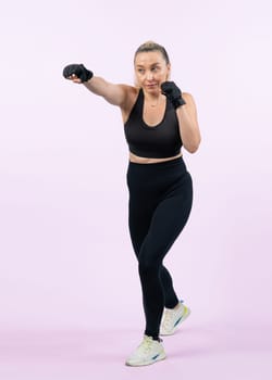 Full body length shot athletic and sporty senior woman doing boxing and punching fist posture on isolated background. Healthy active physique and body care lifestyle after retirement. Clout