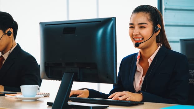 Business people wearing headset working in office to support remote customer or colleague. Call center, telemarketing, customer support agent provide service on telephone video conference call. Jivy