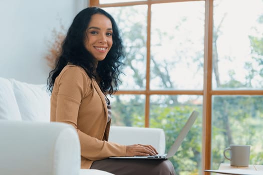 African-American woman using laptop computer for crucial work on internet. Secretary or online content writing working at home.