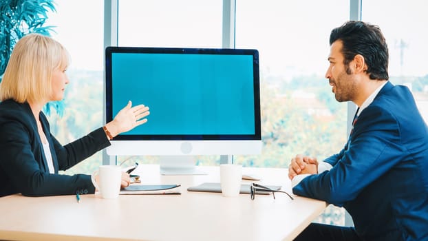 Business people in the conference room with green screen chroma key TV or computer on the office table. Diverse group of businessman and businesswoman in meeting on video conference call . Jivy