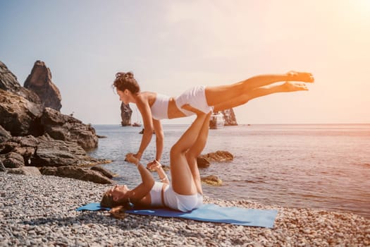 Woman sea yoga. Back view of free calm happy satisfied woman with long hair standing on top rock with yoga position against of sky by the sea. Healthy lifestyle outdoors in nature, fitness concept.