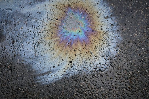 Texture plan of an iridescent oil or gasoline spill on wet pavement, top view