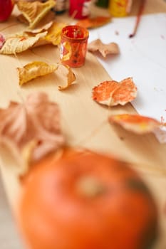 autumn leaves with paintbrush on paper on table, autumn children background