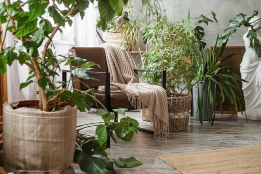 A fragment of the interior with a variety of indoor plants and plaster sculptures. Urban jungle concept. Biophilia design.