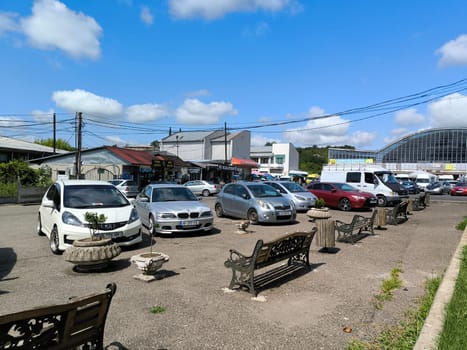 7 August 2024 Tskhaltubo Georgia, market and parking lot transport on the city square, Blue sky clouds summer season street town road car. High quality photo
