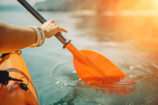 Kayak paddle sea vacation. Person paddles with orange paddle oar on kayak in sea. Leisure active lifestyle recreation activity rest tourism travel.