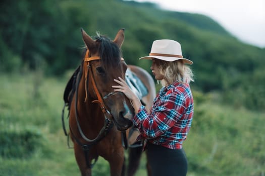 Happy blonde with horse in forest. Woman and a horse walking through the field during the day. Dressed in a plaid shirt and black leggings