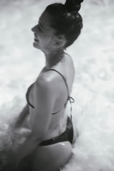 A young woman finds herself enjoying a blissful moment in the water, radiating pure happiness and tranquility