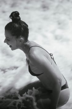 A woman happily revels in the ocean waves, fully embodying a sense of joy and freedom on a beautiful, sunny beach day