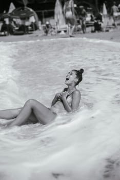 A carefree woman joyfully laughing and splashing in the warm ocean waves, capturing the true essence of summer joy