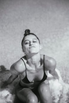 A stunning monochrome portrait of a woman by the shore, beautifully capturing raw beauty and confidence
