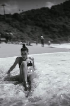 A captivating blackandwhite shot of a woman who is truly enjoying a peaceful and tranquil beach day