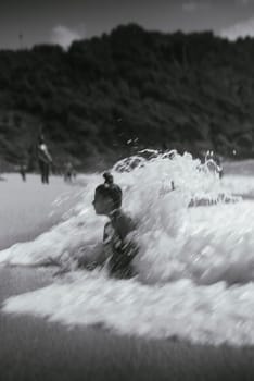 Waves crash energetically at the beach, creating an exhilarating moment that beautifully evokes nostalgia and thrill