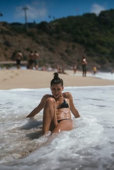 A woman is enjoying herself while relaxing at the beach, capturing the true essence of summer fun and seaside enjoyment