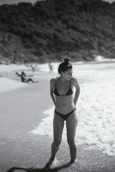 A stunning beach scene with a woman in a stylish bikini, embodying summer vibes and relaxation under the sun