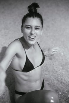 A young woman at the beach relishing a moment filled with joy, spontaneity, and beauty conveyed in black and white