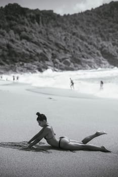 A beautiful and serene beach scene captures a woman stretching, embodying relaxation and the essence of natural beauty