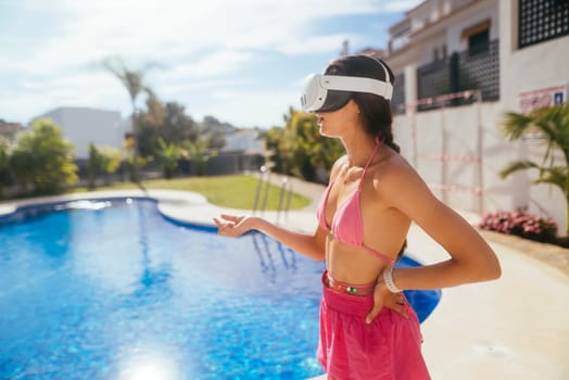 A woman joyfully enjoys virtual reality while unwinding by a vivid blue pool in a beautiful sunny landscape